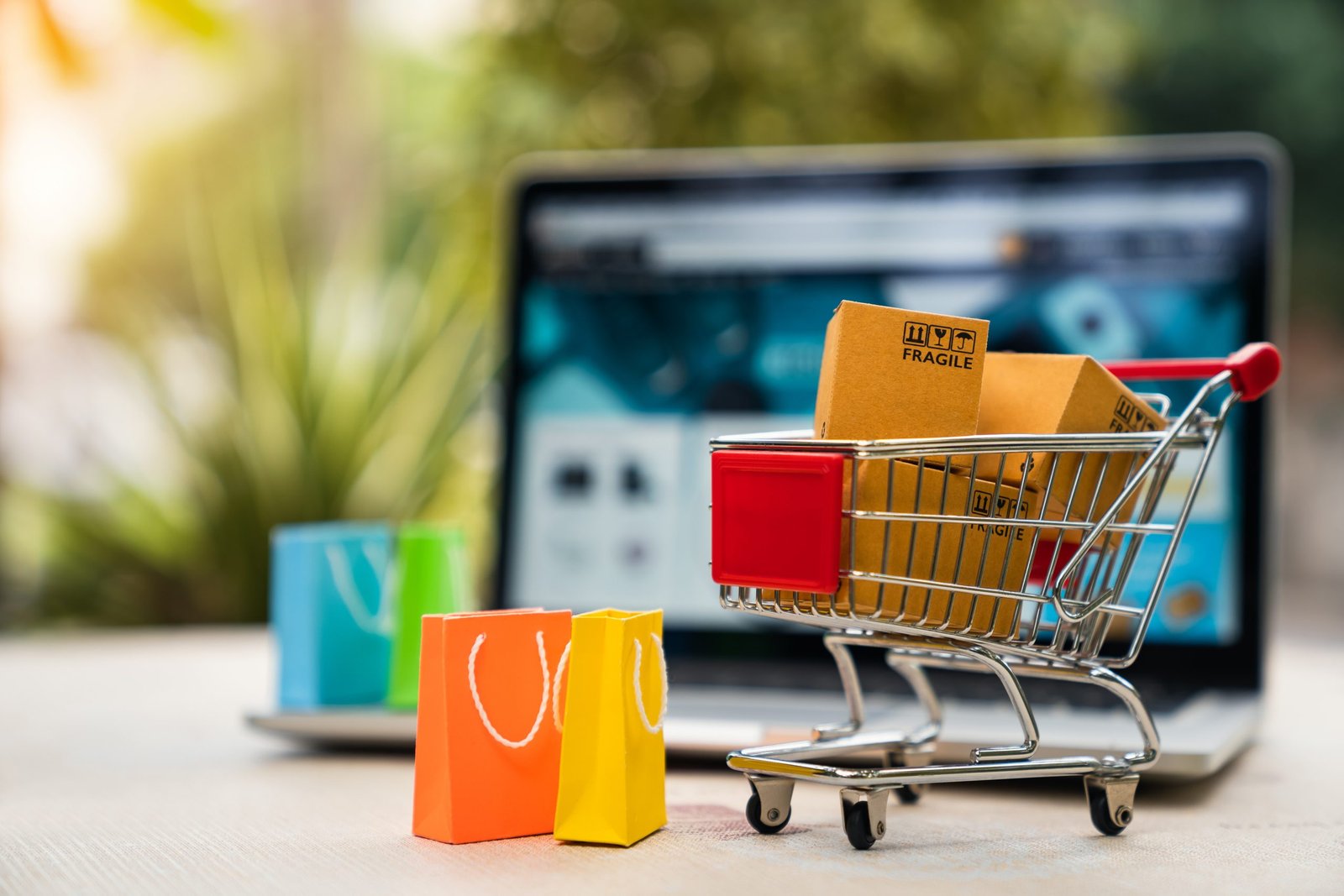 Product package boxes in cart with shopping bag and laptop compu